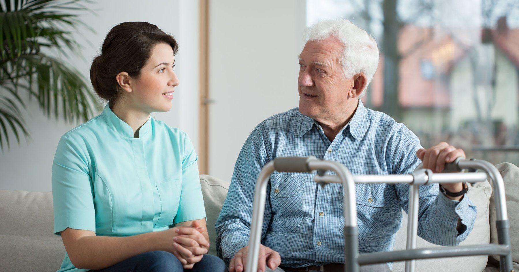 Man with walker talking to a woman