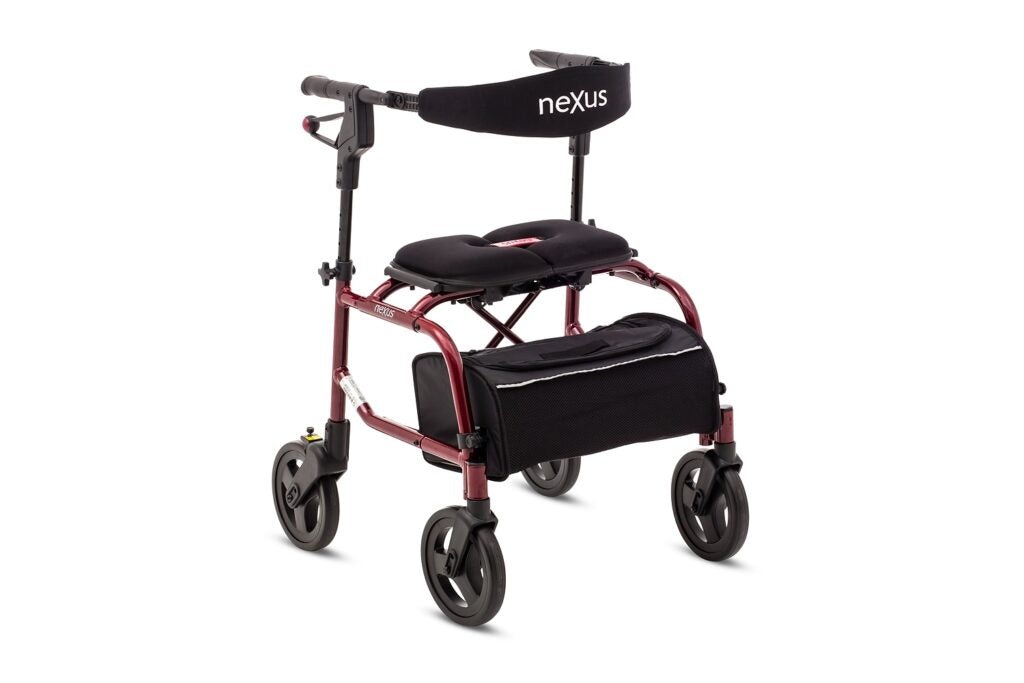 Red NeXus Mobility Walker standing folded with storage bag attached